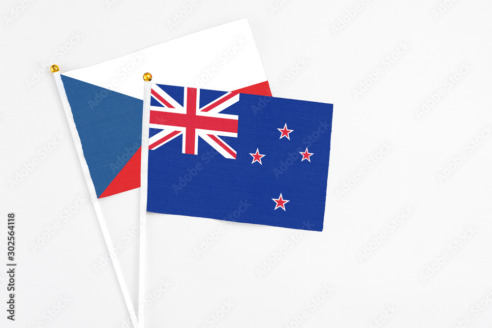 Fototapeta premium New Zealand and Cyprus stick flags on white background. High quality fabric, miniature national flag. Peaceful global concept.White floor for copy space.