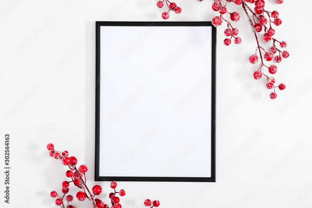 Christmas holiday composition. Black photo frame and red berry on white background. Christmas, New Year, winter concept. Flat lay, top view, copy space - obrazy, fototapety, plakaty 