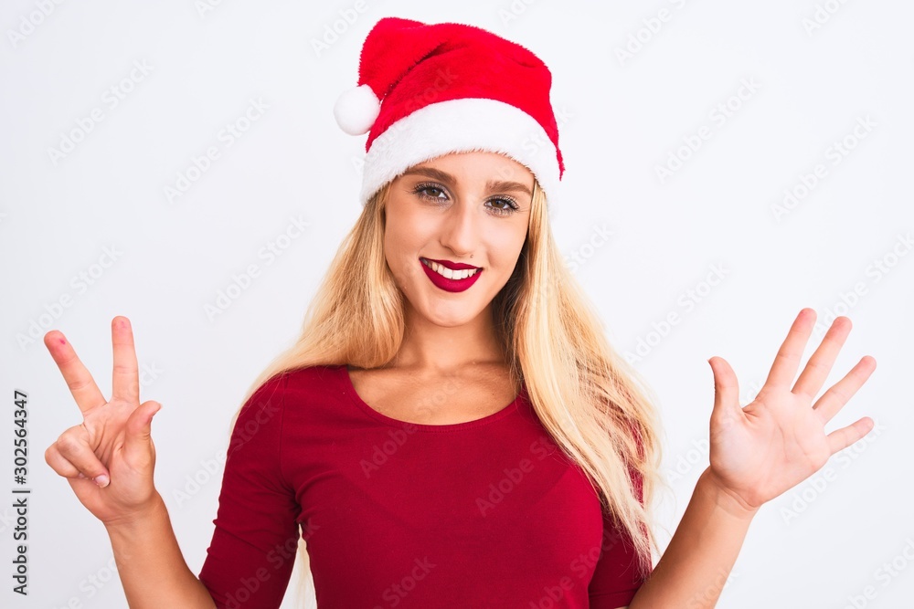 Young beautiful woman wearing Christmas Santa hat over isolated white background showing and pointing up with fingers number eight while smiling confident and happy. Young beautiful woman wearing Christmas Santa hat over isolated white background showing and pointing up with fingers number eight while smiling confident and happy.
