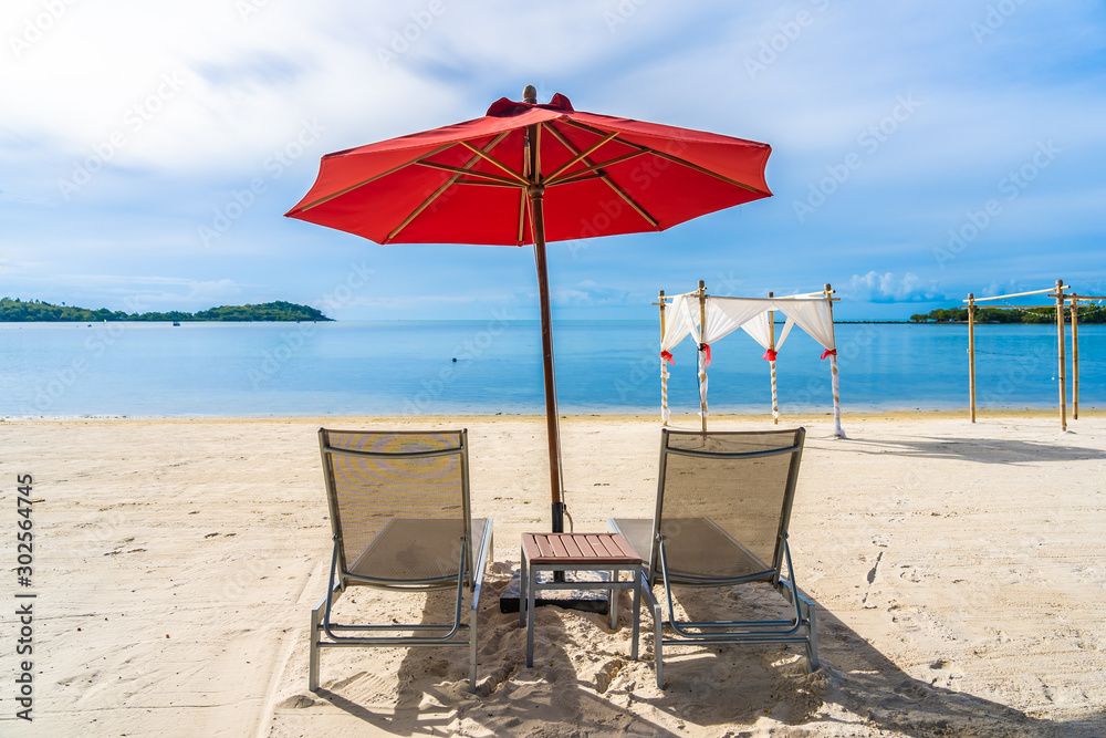 Beautiful outdoor tropical beach sea ocean with umbrella chair and lounge deck around there on white cloud blue sky