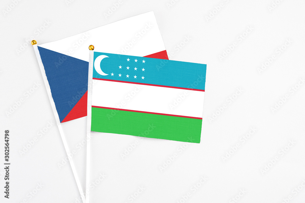 Uzbekistan and Cyprus stick flags on white background. High quality fabric, miniature national flag. Peaceful global concept.White floor for copy space. Uzbekistan and Cyprus stick flags on white background. High quality fabric, miniature national flag. Peaceful global concept.White floor for copy space.