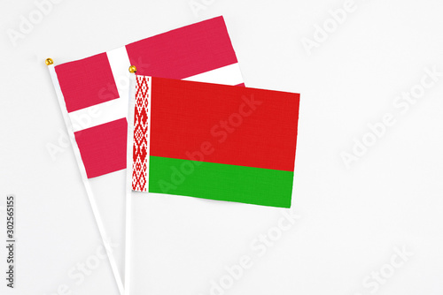 Belarus and Denmark stick flags on white background. High quality fabric, miniature national flag. Peaceful global concept.White floor for copy space. photo