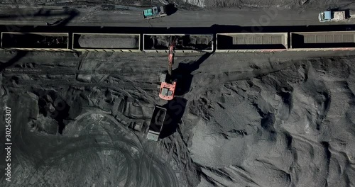View from above. Coal port. The excavator is engaged in loading coal into railway cars.