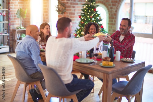 Beautiful family smiling happy and confident. Eating roasted turkey celebrating Christmas at home