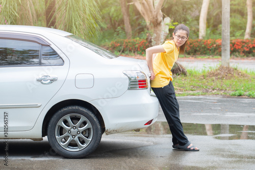 Side view of young woman pushing broken car on the road. Situation when car break down on the road. © boyloso