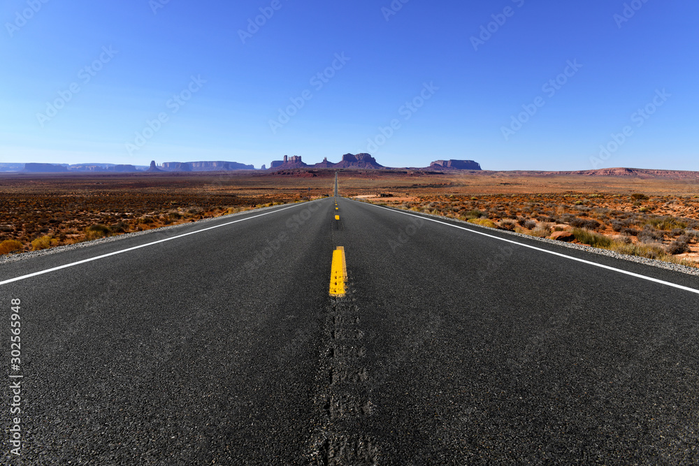 Road into the red rock desert landscape of Monument Valley, Navajo Tribal Park in the southwest USA in Arizona and Utah Road into the red rock desert landscape of Monument Valley, Navajo Tribal Park in the southwest USA in Arizona and Utah