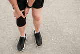 Closeup of runner woman wearing knee support to prevent and reduce knee pain from running. Conceptual of injury from running workout.