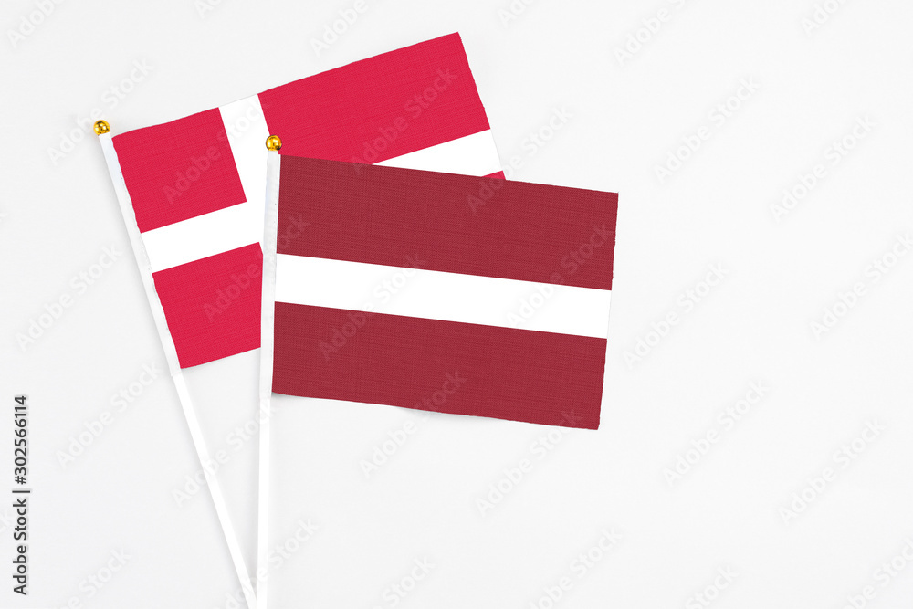 Latvia and Denmark stick flags on white background. High quality fabric, miniature national flag. Peaceful global concept.White floor for copy space. Latvia and Denmark stick flags on white background. High quality fabric, miniature national flag. Peaceful global concept.White floor for copy space.