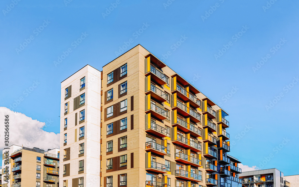 Fragment of Modern residential apartment and flat buildings exterior. Detail of New luxury house and home complex. Part of City Real estate property and condo architecture. Copy space. Blue sky