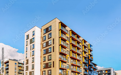 Fragment of Modern residential apartment and flat buildings exterior. Detail of New luxury house and home complex. Part of City Real estate property and condo architecture. Copy space. Blue sky © Roman Babakin