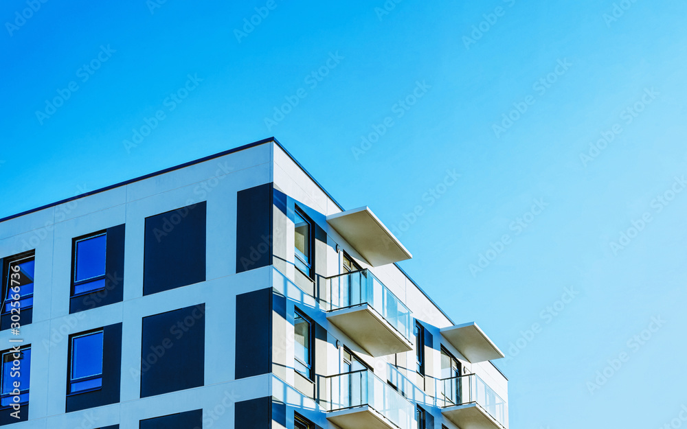 Part in Modern residential apartment and flat building exterior. Detail of New luxury house and home complex. Fragment of City Real estate property and condo architecture. Copy space. Blue sky