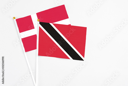 Trinidad And Tobago and Denmark stick flags on white background. High quality fabric, miniature national flag. Peaceful global concept.White floor for copy space.