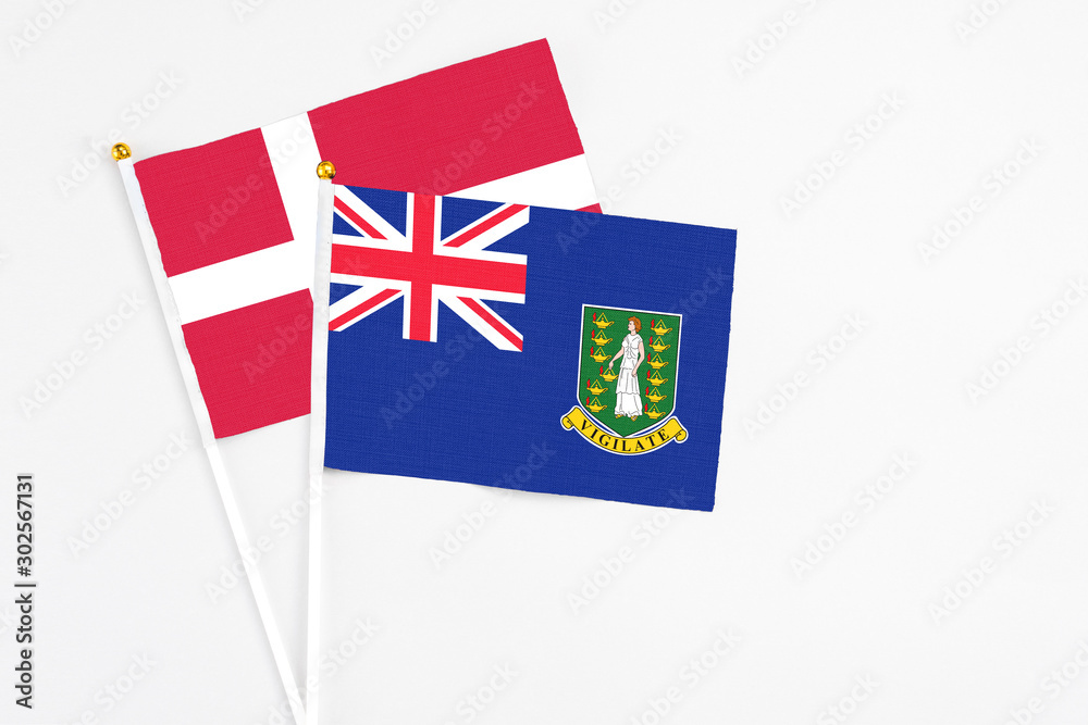 Fototapeta premium British Virgin Islands and Denmark stick flags on white background. High quality fabric, miniature national flag. Peaceful global concept.White floor for copy space.
