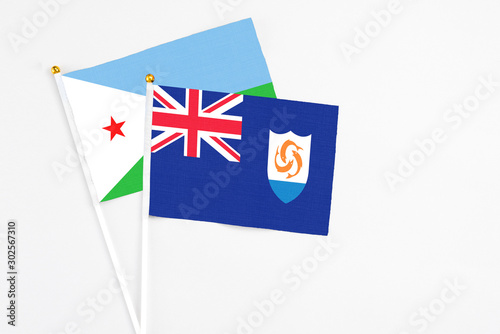 Anguilla and Djibouti stick flags on white background. High quality fabric, miniature national flag. Peaceful global concept.White floor for copy space.
