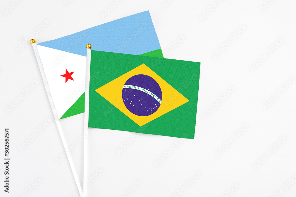Brazil and Djibouti stick flags on white background. High quality fabric, miniature national flag. Peaceful global concept.White floor for copy space.