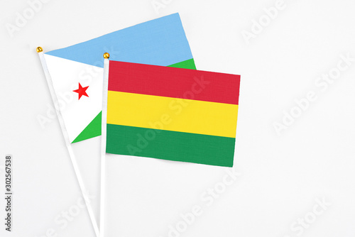 Bolivia and Djibouti stick flags on white background. High quality fabric, miniature national flag. Peaceful global concept.White floor for copy space.