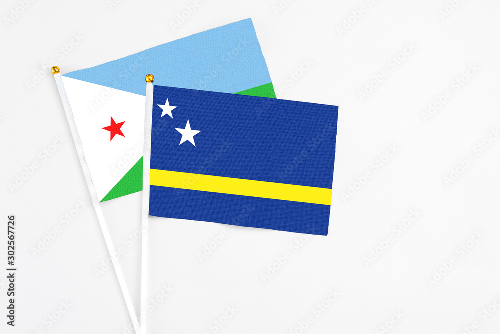Curacao and Djibouti stick flags on white background. High quality fabric, miniature national flag. Peaceful global concept.White floor for copy space.