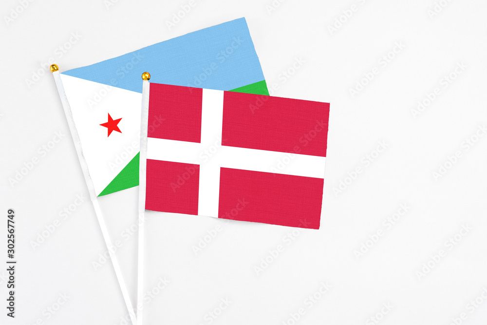 Denmark and Djibouti stick flags on white background. High quality fabric, miniature national flag. Peaceful global concept.White floor for copy space.