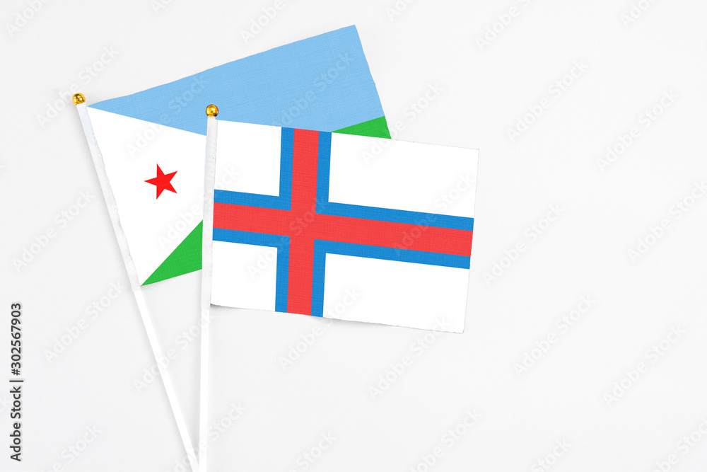Faroe Islands and Djibouti stick flags on white background. High quality fabric, miniature national flag. Peaceful global concept.White floor for copy space.