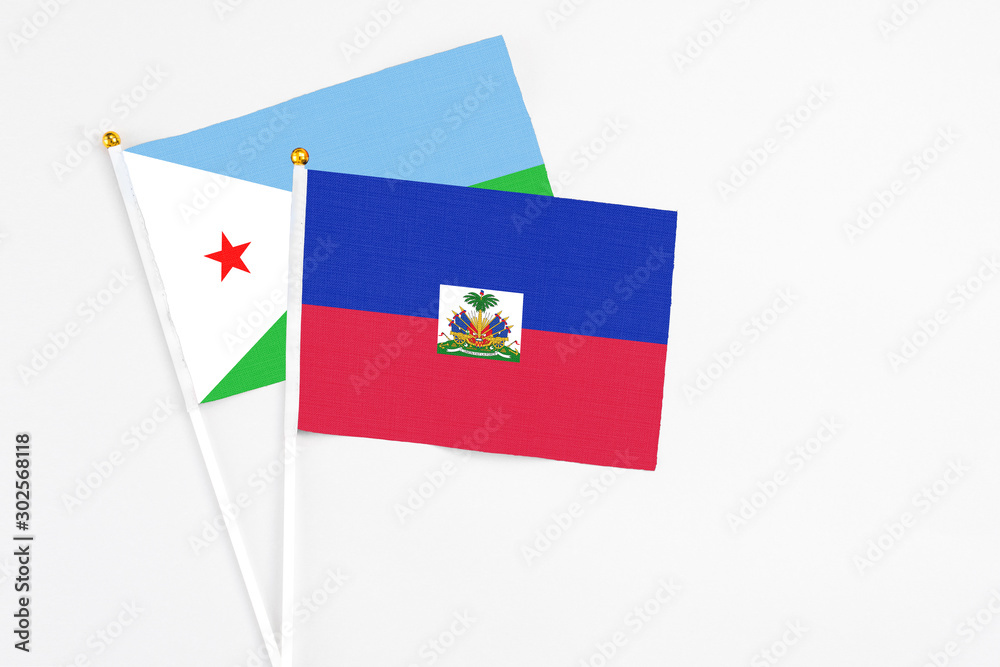 Haiti and Djibouti stick flags on white background. High quality fabric, miniature national flag. Peaceful global concept.White floor for copy space. Haiti and Djibouti stick flags on white background. High quality fabric, miniature national flag. Peaceful global concept.White floor for copy space.
