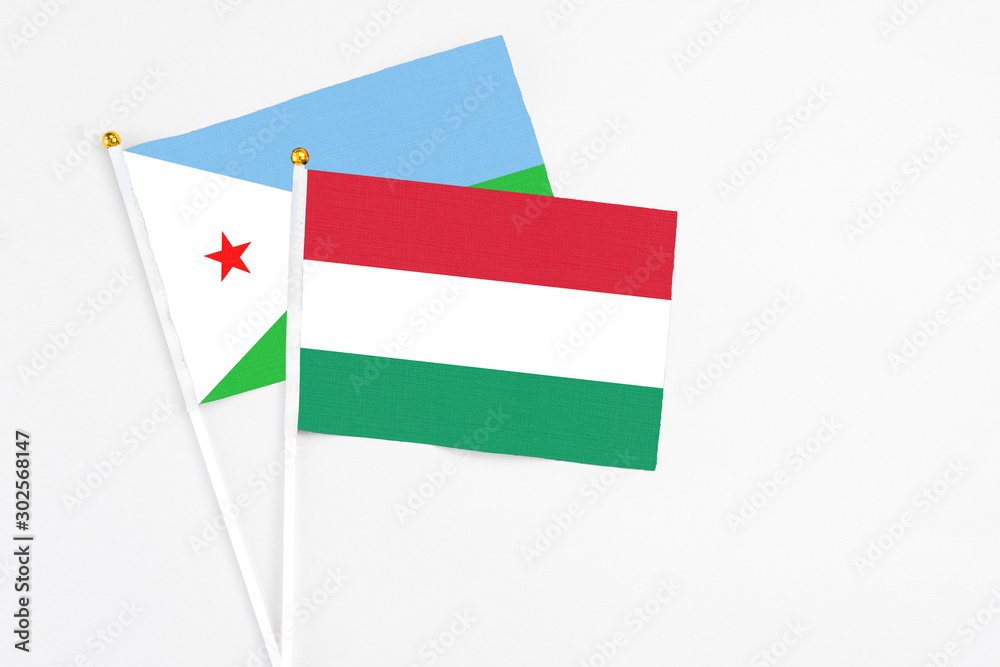 Hungary and Djibouti stick flags on white background. High quality fabric, miniature national flag. Peaceful global concept.White floor for copy space. Hungary and Djibouti stick flags on white background. High quality fabric, miniature national flag. Peaceful global concept.White floor for copy space.