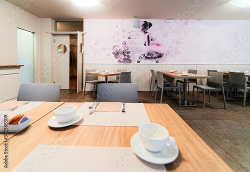 Fotka „Hotel breakfast restaurant interior on background. Empty  architecture white room. Bar with tables and cups and chairs. Light Vintage  style. Morning design. Cafe. Lunch, dinner snack. Modern lifestyle“ ze  služby Stock | Adobe Stock