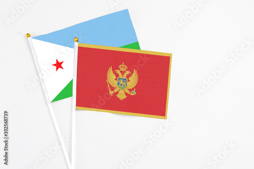 Montenegro and Djibouti stick flags on white background. High quality fabric, miniature national flag. Peaceful global concept.White floor for copy space.