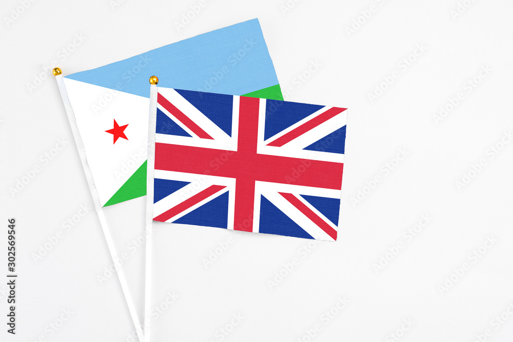 United Kingdom and Djibouti stick flags on white background. High quality fabric, miniature national flag. Peaceful global concept.White floor for copy space. United Kingdom and Djibouti stick flags on white background. High quality fabric, miniature national flag. Peaceful global concept.White floor for copy space.