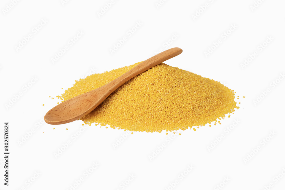 millet pile and wooden spoon on white background