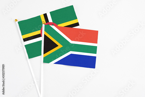 South Africa and Dominica stick flags on white background. High quality fabric  miniature national flag. Peaceful global concept.White floor for copy space.