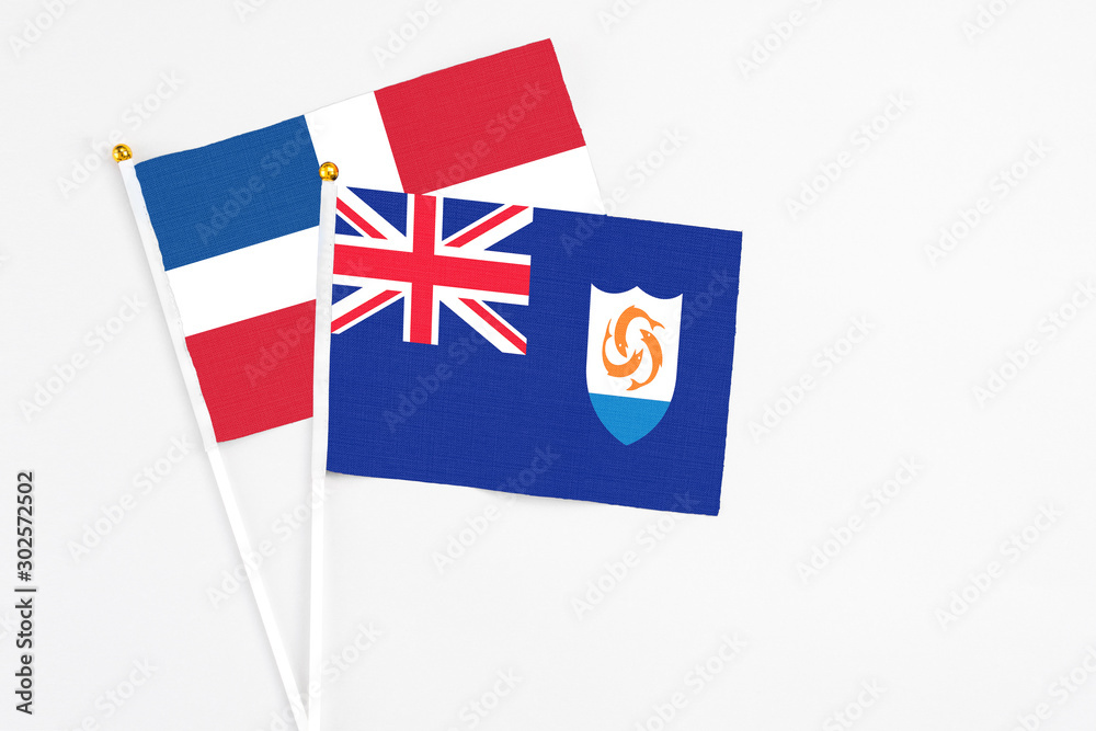 Fototapeta premium Anguilla and Dominican Republic stick flags on white background. High quality fabric, miniature national flag. Peaceful global concept.White floor for copy space.