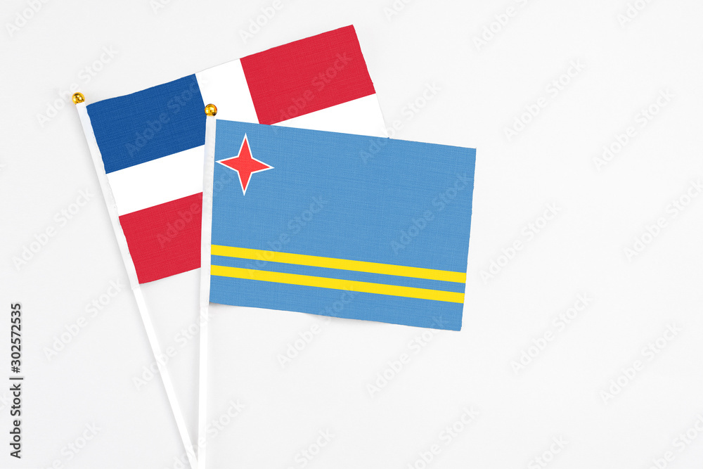 Aruba and Dominican Republic stick flags on white background. High quality fabric, miniature national flag. Peaceful global concept.White floor for copy space. Aruba and Dominican Republic stick flags on white background. High quality fabric, miniature national flag. Peaceful global concept.White floor for copy space.