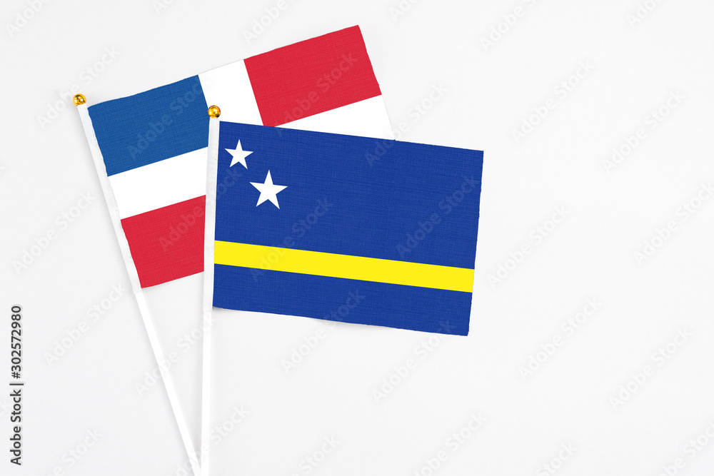 Curacao and Dominican Republic stick flags on white background. High quality fabric, miniature national flag. Peaceful global concept.White floor for copy space. Curacao and Dominican Republic stick flags on white background. High quality fabric, miniature national flag. Peaceful global concept.White floor for copy space.