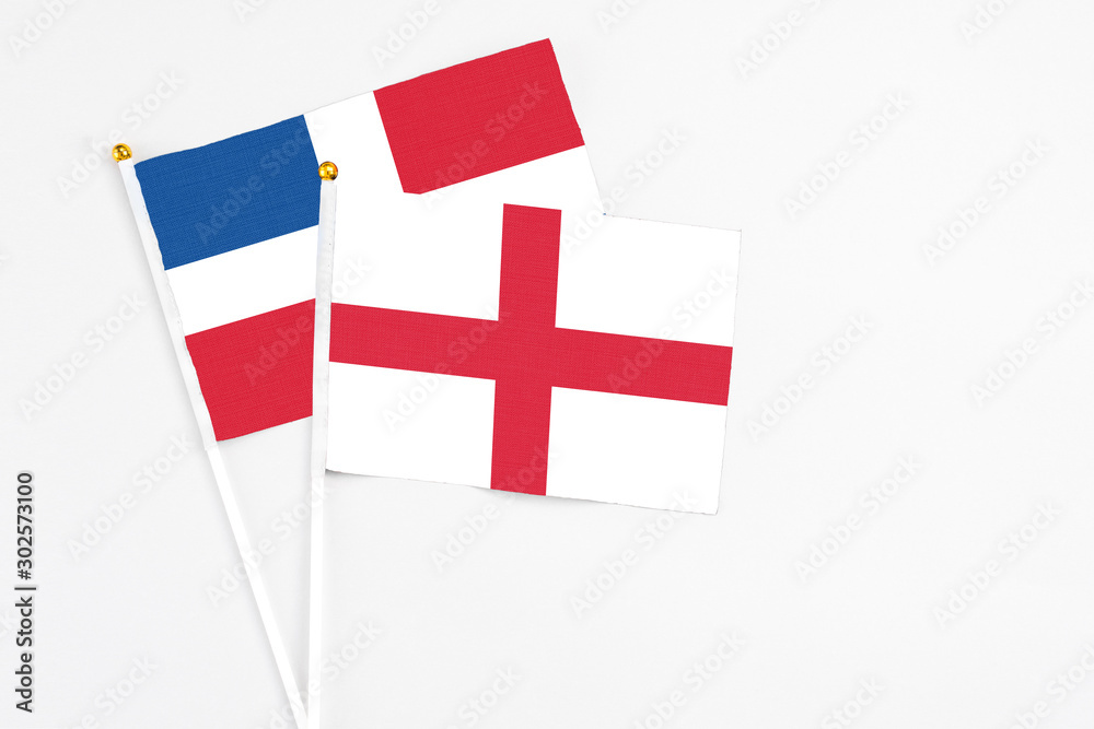 England and Dominican Republic stick flags on white background. High quality fabric, miniature national flag. Peaceful global concept.White floor for copy space.