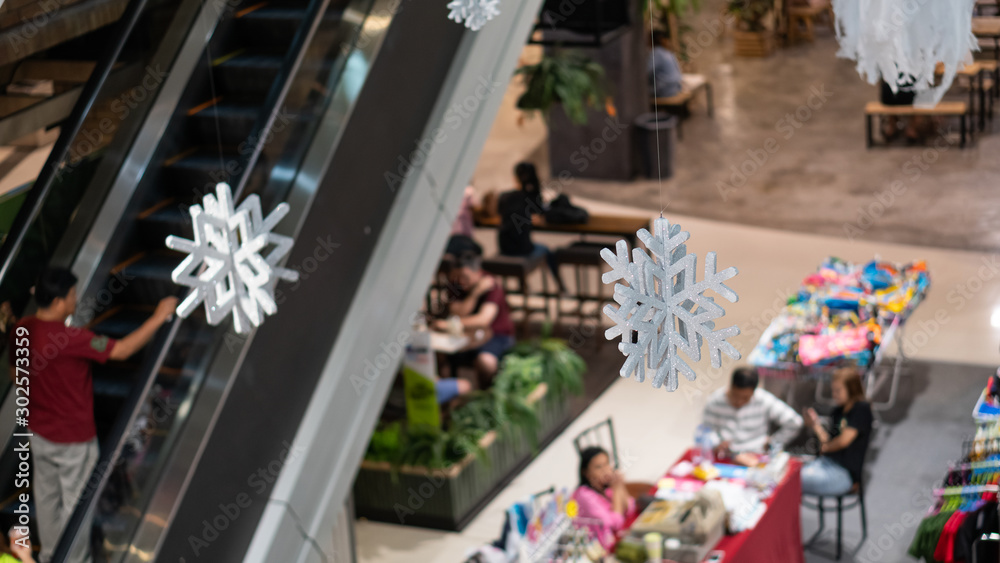 Many snowflake symbols hung beside the stairs in a mall in Thailand. Many snowflake symbols hung beside the stairs in a mall in Thailand.