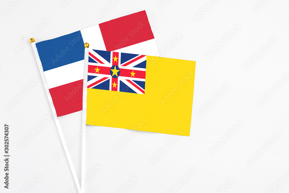 Niue and Dominican Republic stick flags on white background. High quality fabric, miniature national flag. Peaceful global concept.White floor for copy space. Niue and Dominican Republic stick flags on white background. High quality fabric, miniature national flag. Peaceful global concept.White floor for copy space.