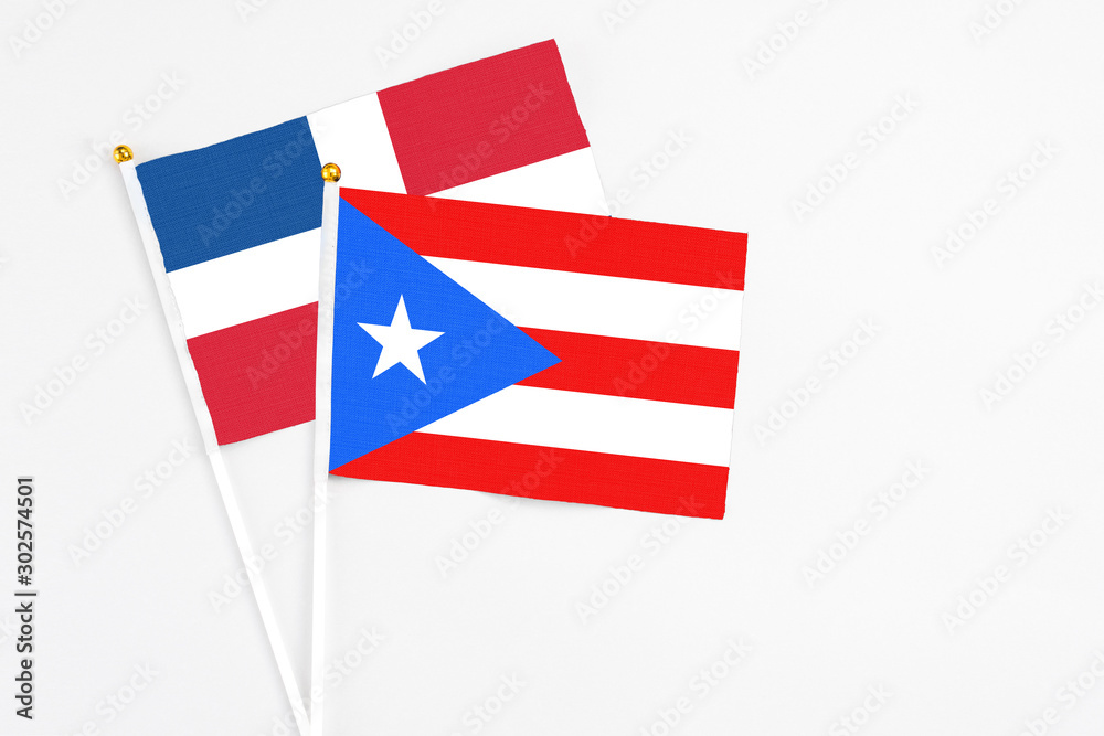 Puerto Rico and Dominican Republic stick flags on white background. High quality fabric, miniature national flag. Peaceful global concept.White floor for copy space. Puerto Rico and Dominican Republic stick flags on white background. High quality fabric, miniature national flag. Peaceful global concept.White floor for copy space.