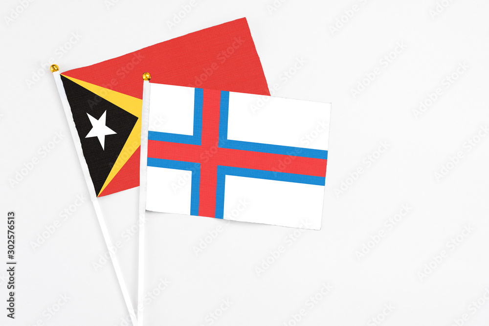Faroe Islands and East Timor stick flags on white background. High quality fabric, miniature national flag. Peaceful global concept.White floor for copy space. Faroe Islands and East Timor stick flags on white background. High quality fabric, miniature national flag. Peaceful global concept.White floor for copy space.