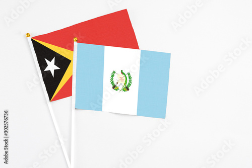 Guatemala and East Timor stick flags on white background. High quality fabric, miniature national flag. Peaceful global concept.White floor for copy space.