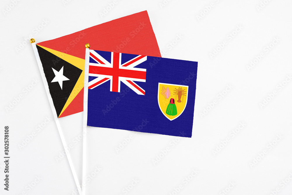 Turks And Caicos Islands and East Timor stick flags on white background. High quality fabric, miniature national flag. Peaceful global concept.White floor for copy space. Turks And Caicos Islands and East Timor stick flags on white background. High quality fabric, miniature national flag. Peaceful global concept.White floor for copy space.