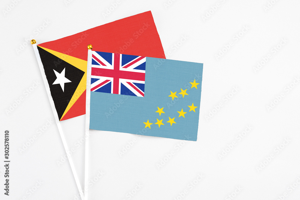 Tuvalu and East Timor stick flags on white background. High quality fabric, miniature national flag. Peaceful global concept.White floor for copy space. Tuvalu and East Timor stick flags on white background. High quality fabric, miniature national flag. Peaceful global concept.White floor for copy space.