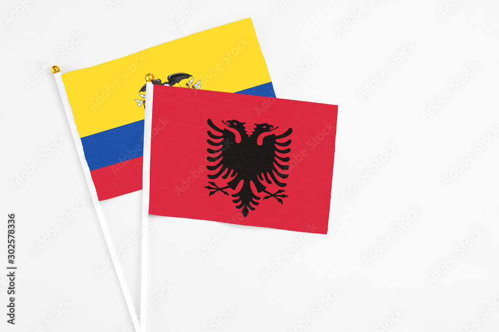 Albania and Ecuador stick flags on white background. High quality fabric, miniature national flag. Peaceful global concept.White floor for copy space.