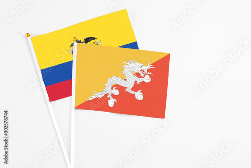 Bhutan and Ecuador stick flags on white background. High quality fabric, miniature national flag. Peaceful global concept.White floor for copy space.