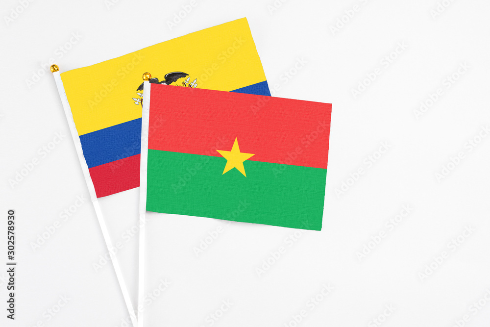 Burkina Faso and Ecuador stick flags on white background. High quality fabric, miniature national flag. Peaceful global concept.White floor for copy space.