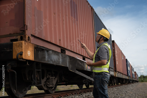 Male engineer, worker inspection checking on container on the train.