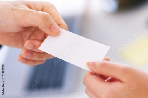 Two businessman holding and giving empty business card