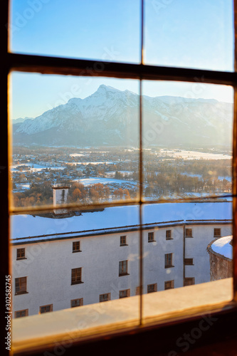 View from window glass on Salzburg of Austria in snow. Mozart city in Europe at winter. Travel at Alps. Cityscape  Panorama and landmark. Panoramic view on roofs of old Austrian town of Salzburgerland