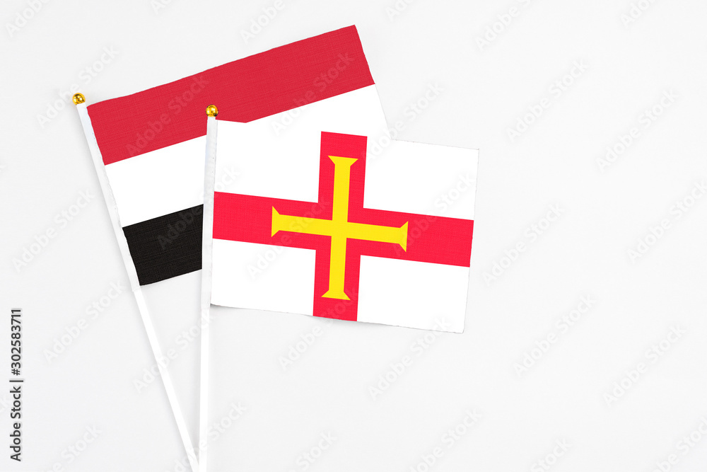 Guernsey and Egypt stick flags on white background. High quality fabric, miniature national flag. Peaceful global concept.White floor for copy space.