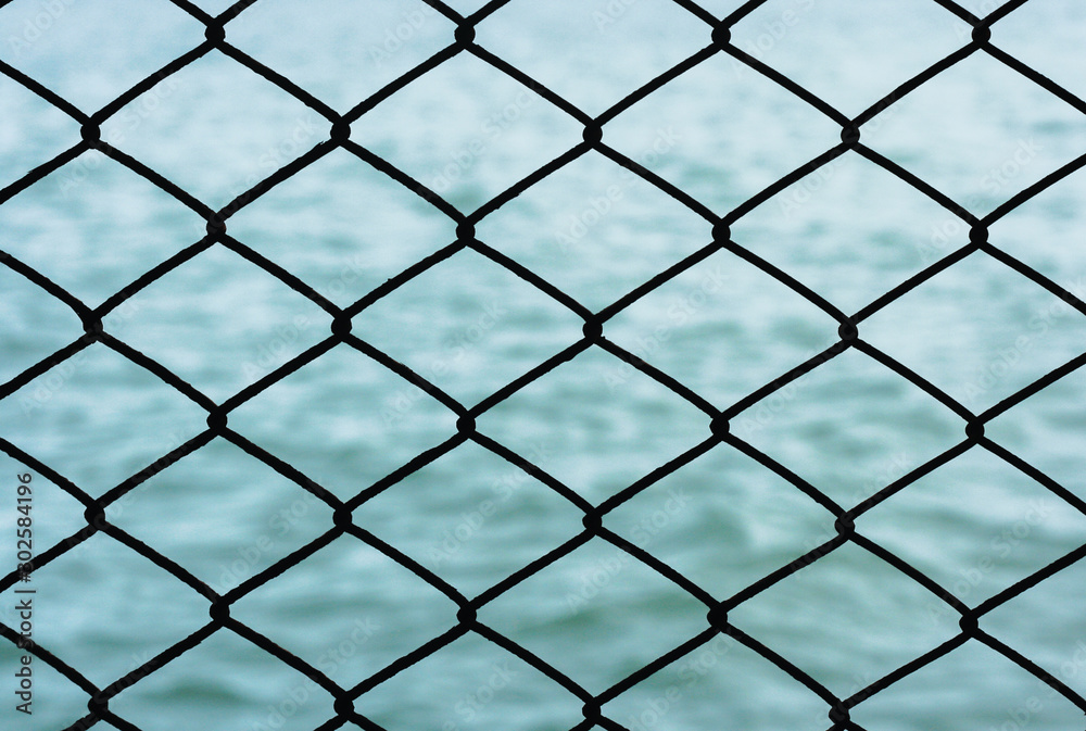 Grille iron fence with sea background. Concept of hinder/ protect freedom, peaceful life with strong wall. Grille iron fence with sea background. Concept of hinder/ protect freedom, peaceful life with strong wall.