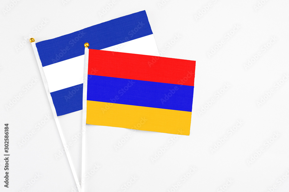 Fototapeta premium Armenia and El Salvador stick flags on white background. High quality fabric, miniature national flag. Peaceful global concept.White floor for copy space.